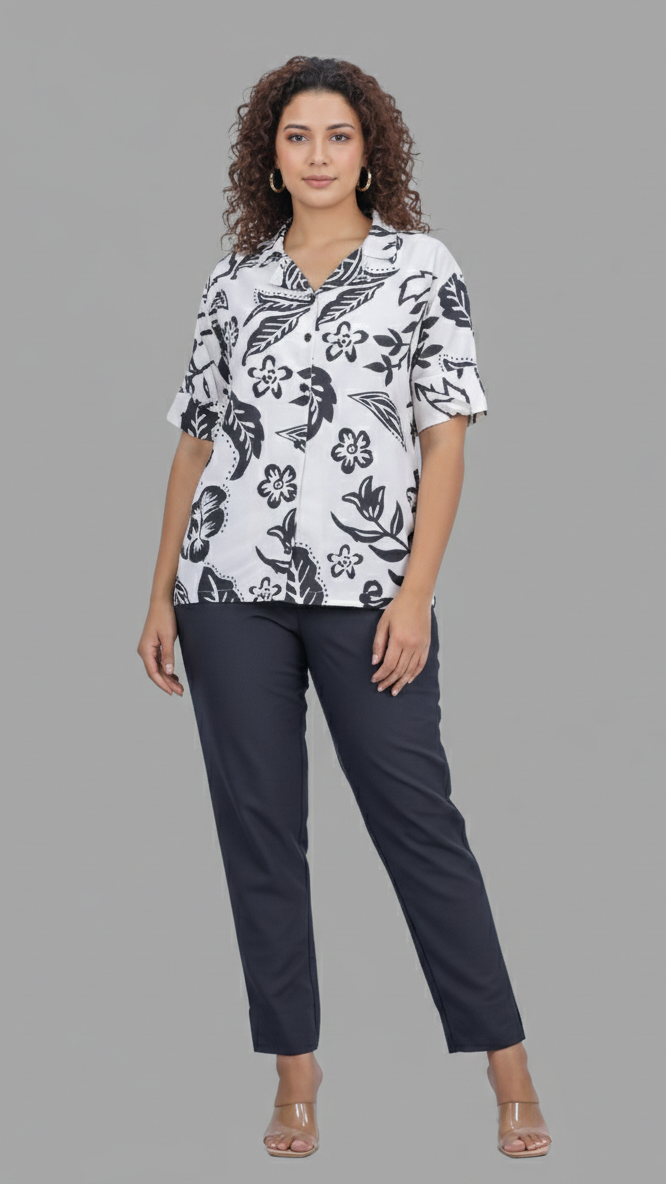 Woman wearing a floral blouse and black pants on a gray background
