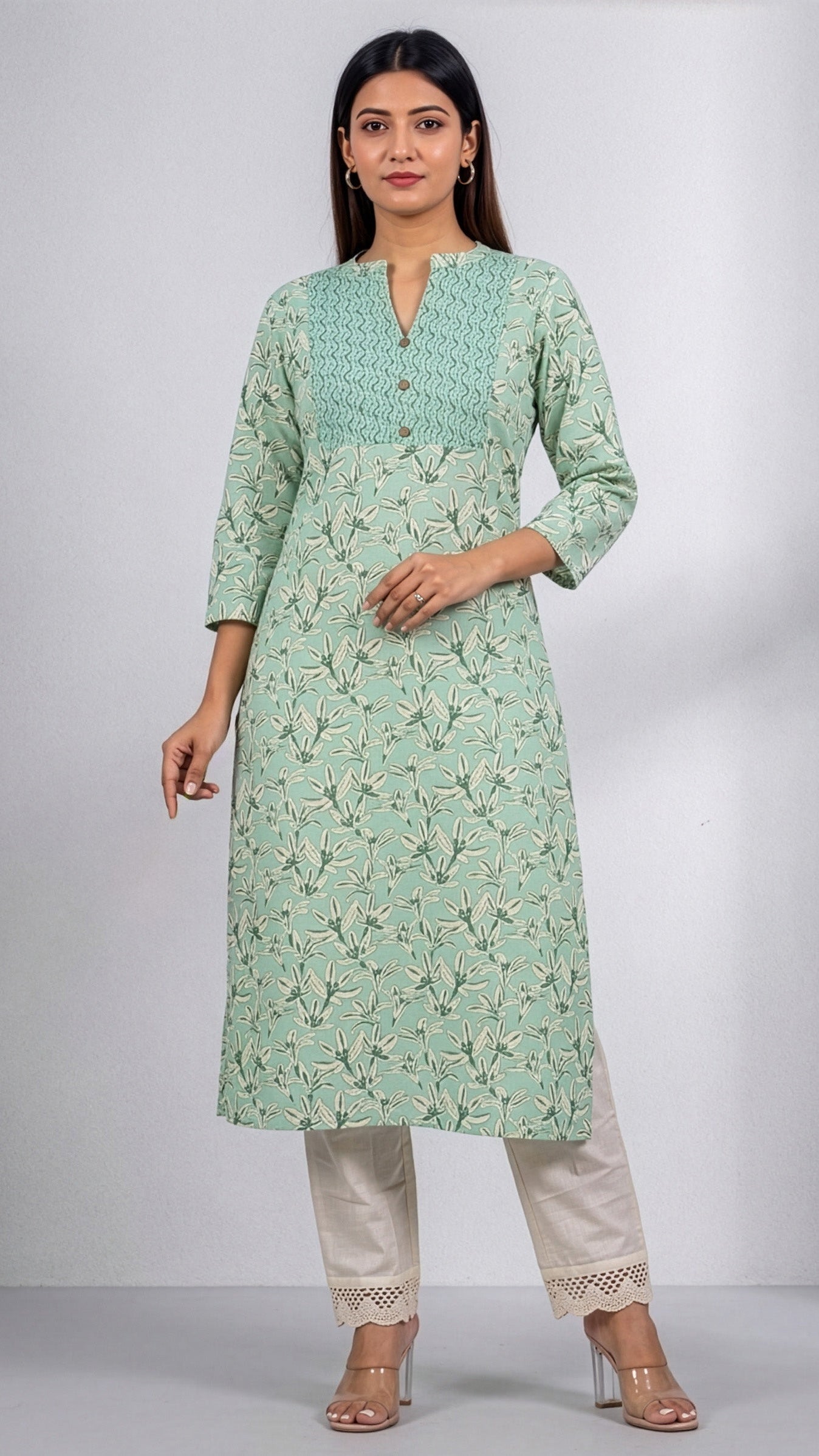 Woman wearing a light green floral kurta with beige pants on a gray background