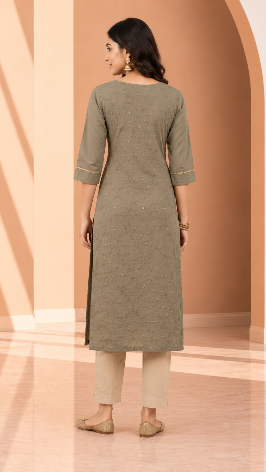 A woman stands with her back to the camera wearing a muted olive green three-quarter sleeve kurta with subtle embroidered details, paired with beige cropped pants and beige flats, set against a warm beige architectural background.