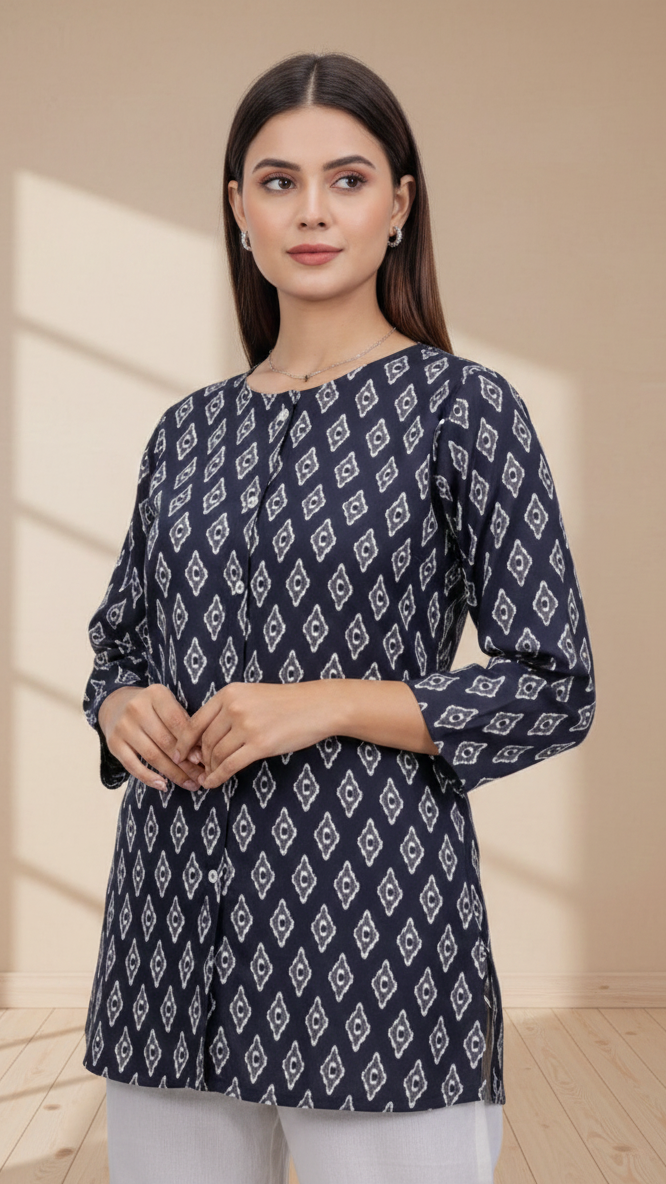 Woman wearing a navy blue patterned top with white pants against a beige background