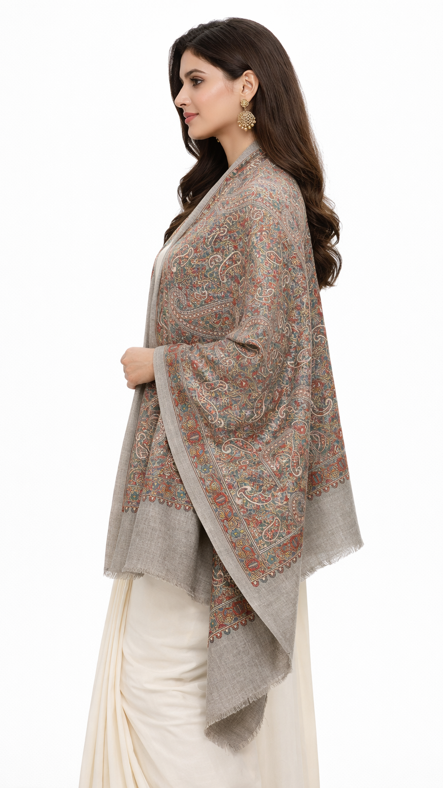 Woman wearing a patterned shawl over a white saree on a white background