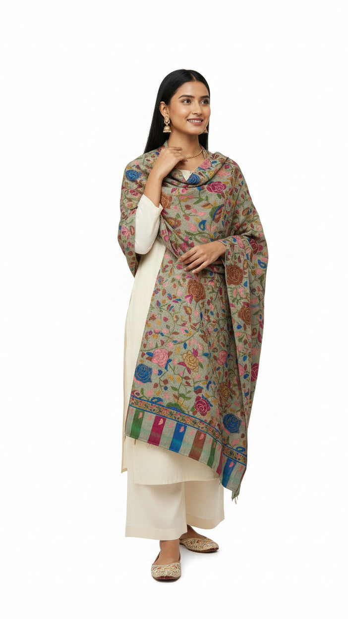 Woman wearing a floral patterned shawl over a white outfit on a white background