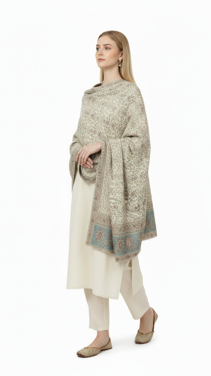 Woman wearing a patterned shawl over a white outfit on a white background