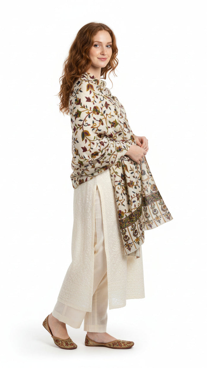 Woman wearing a patterned shawl over a white outfit on a white background