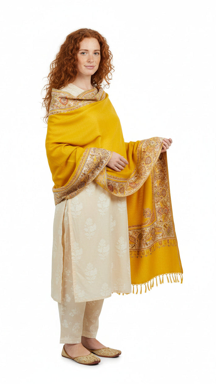 Woman wearing a yellow and beige traditional outfit with a matching shawl on a white background