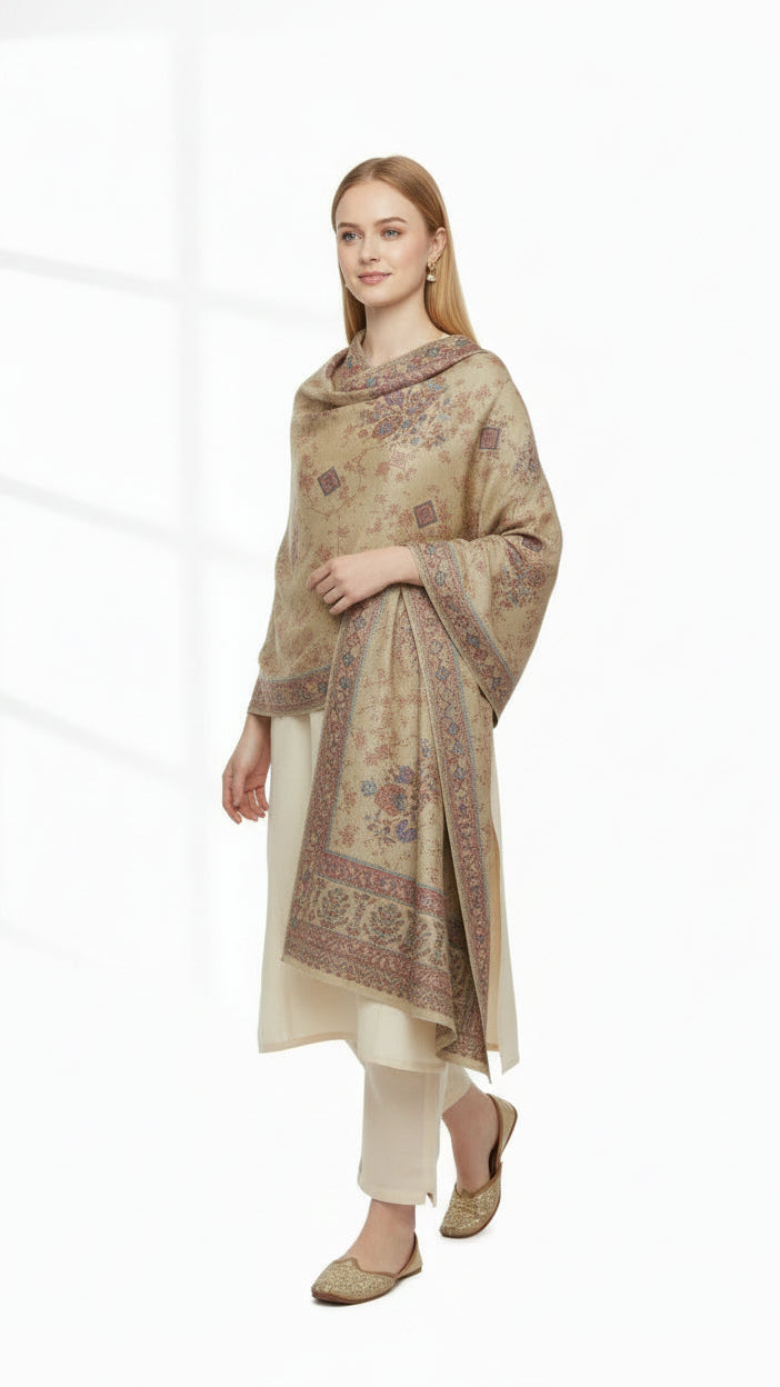 Woman wearing a beige embroidered dupatta over a kurta with white pants on a white background