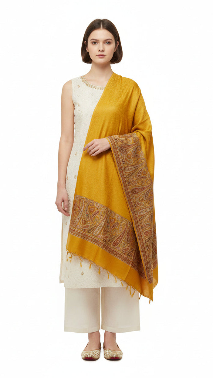 Woman wearing a mustard yellow dupatta with intricate patterns on a white background