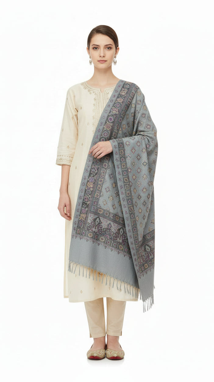 Woman wearing a light-colored kurta with a patterned shawl on a white background