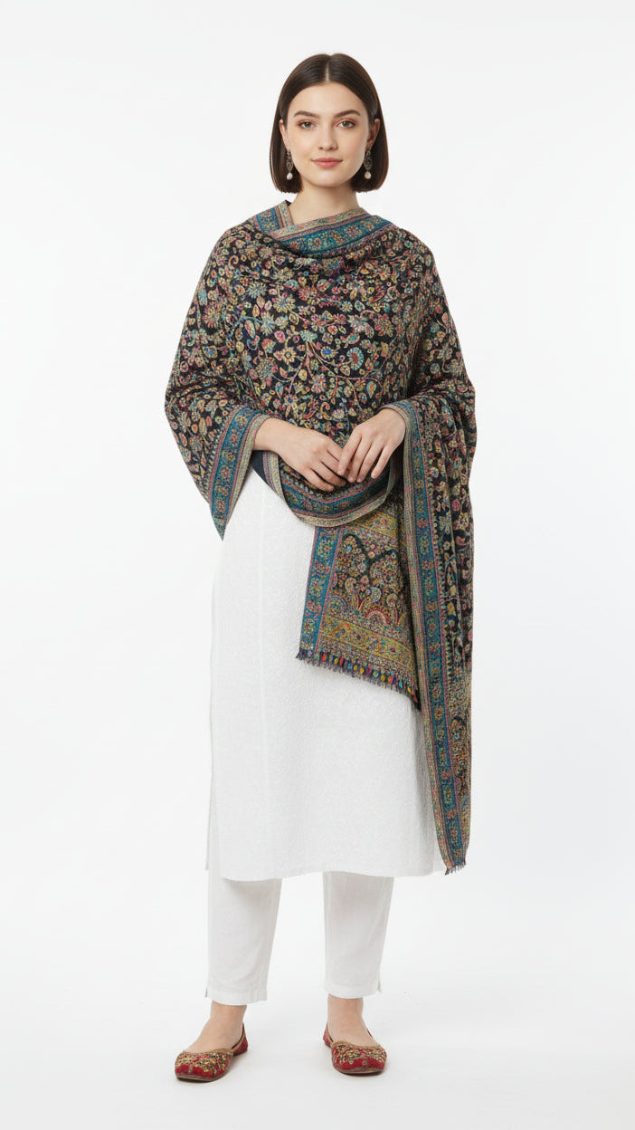 Woman wearing a patterned shawl over a white outfit on a white background