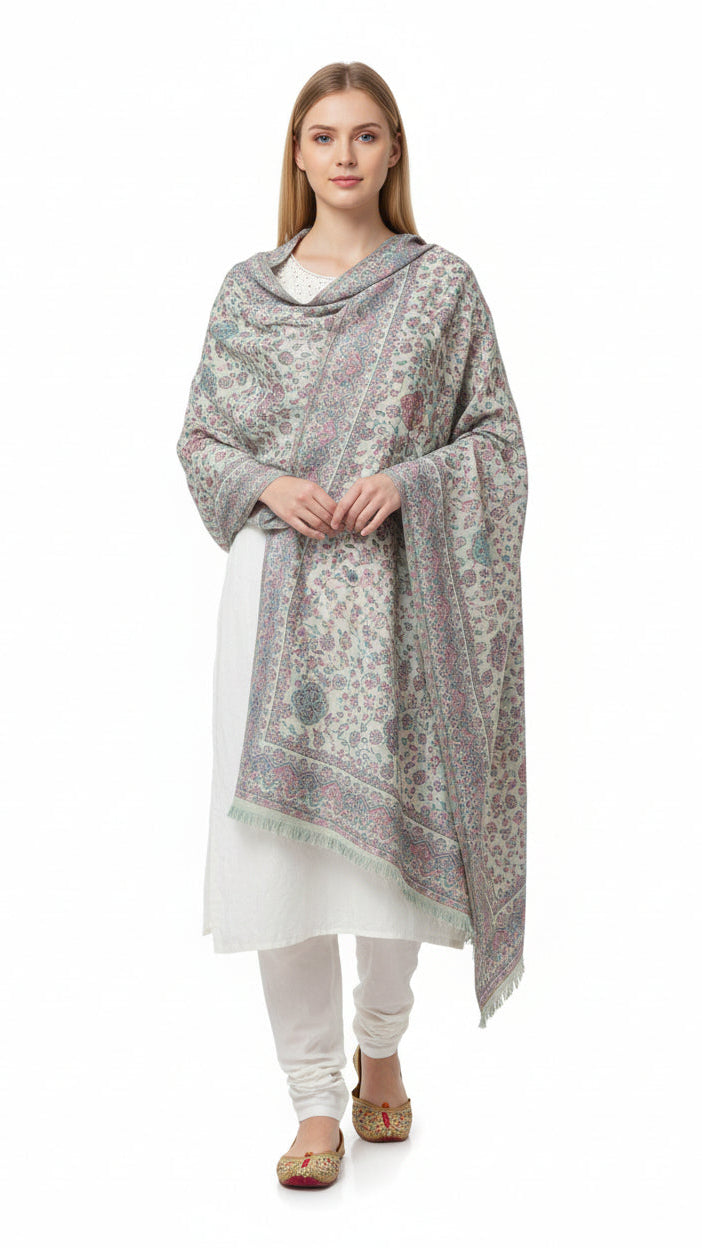 Woman wearing a patterned shawl over a white outfit on a white background