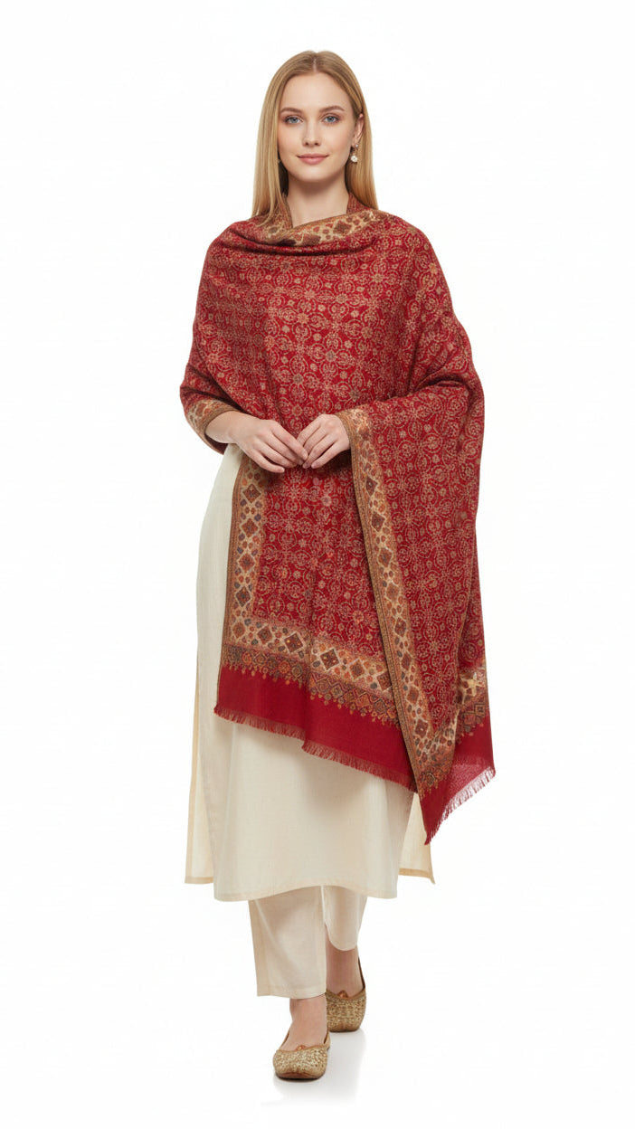 Woman wearing a red patterned shawl over a white outfit on a white background