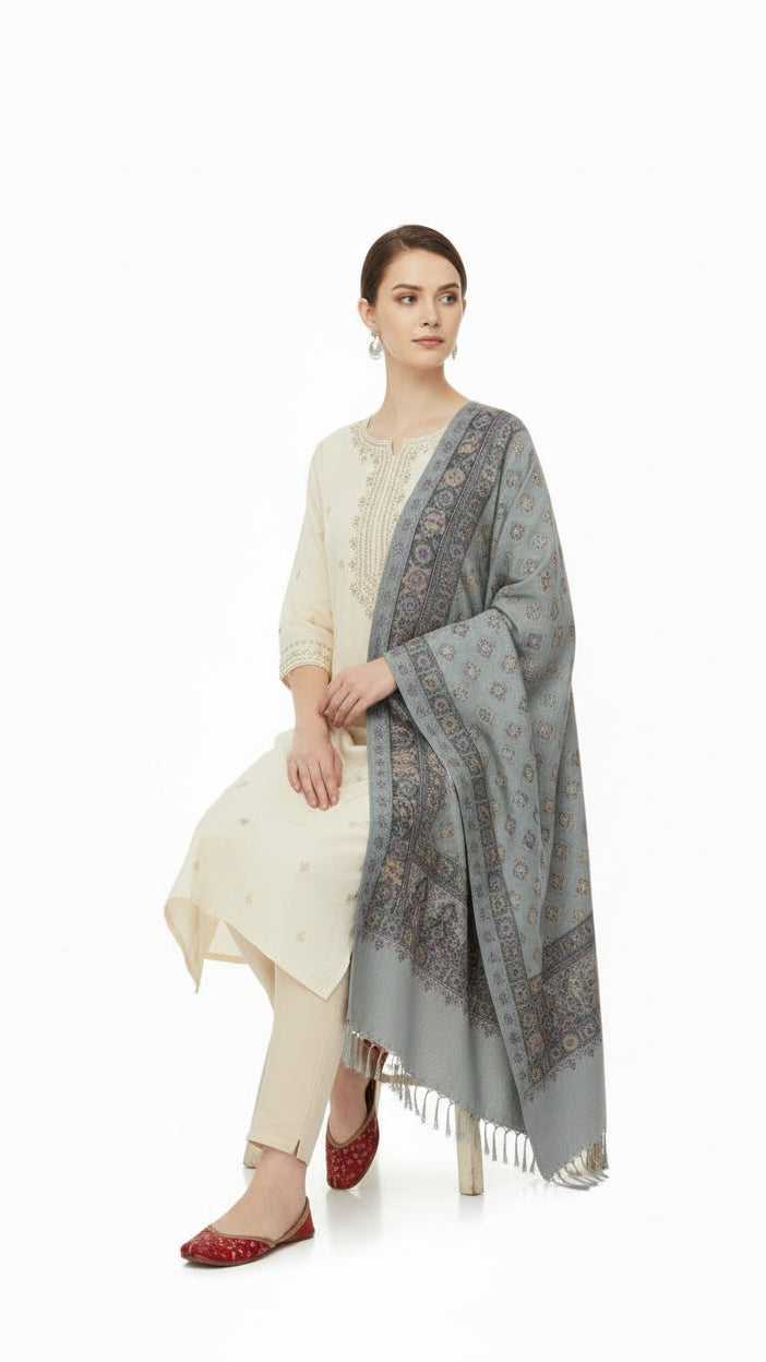 Woman wearing a white kurta with beige pants and a gray patterned shawl on a white background